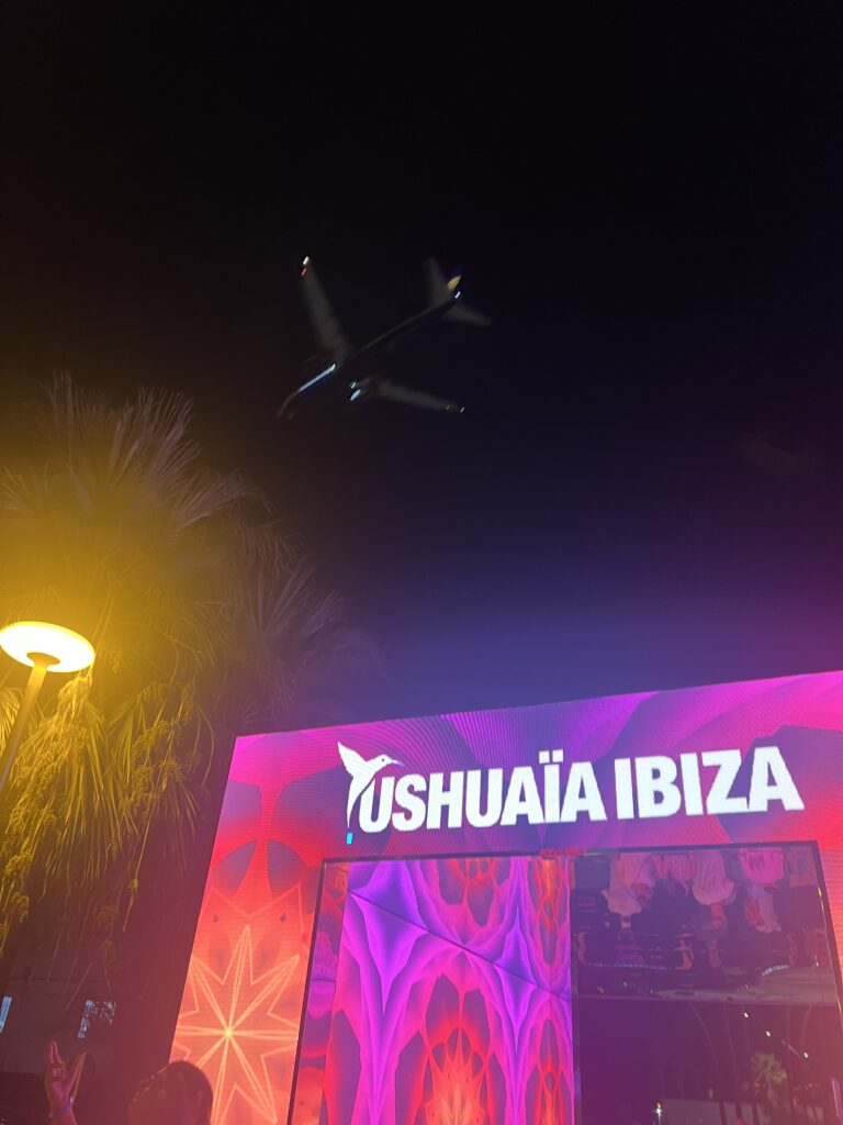 Plane flying above the entrance of Ushuaïa Ibiza at night